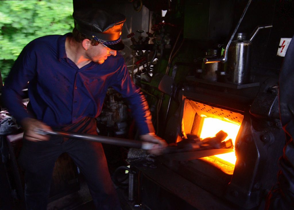 1280px-Baureihe52Heizer, Heizer bei der Arbeit auf der Lokomotive Baureihe 52 7409 Stadt Würzburg.